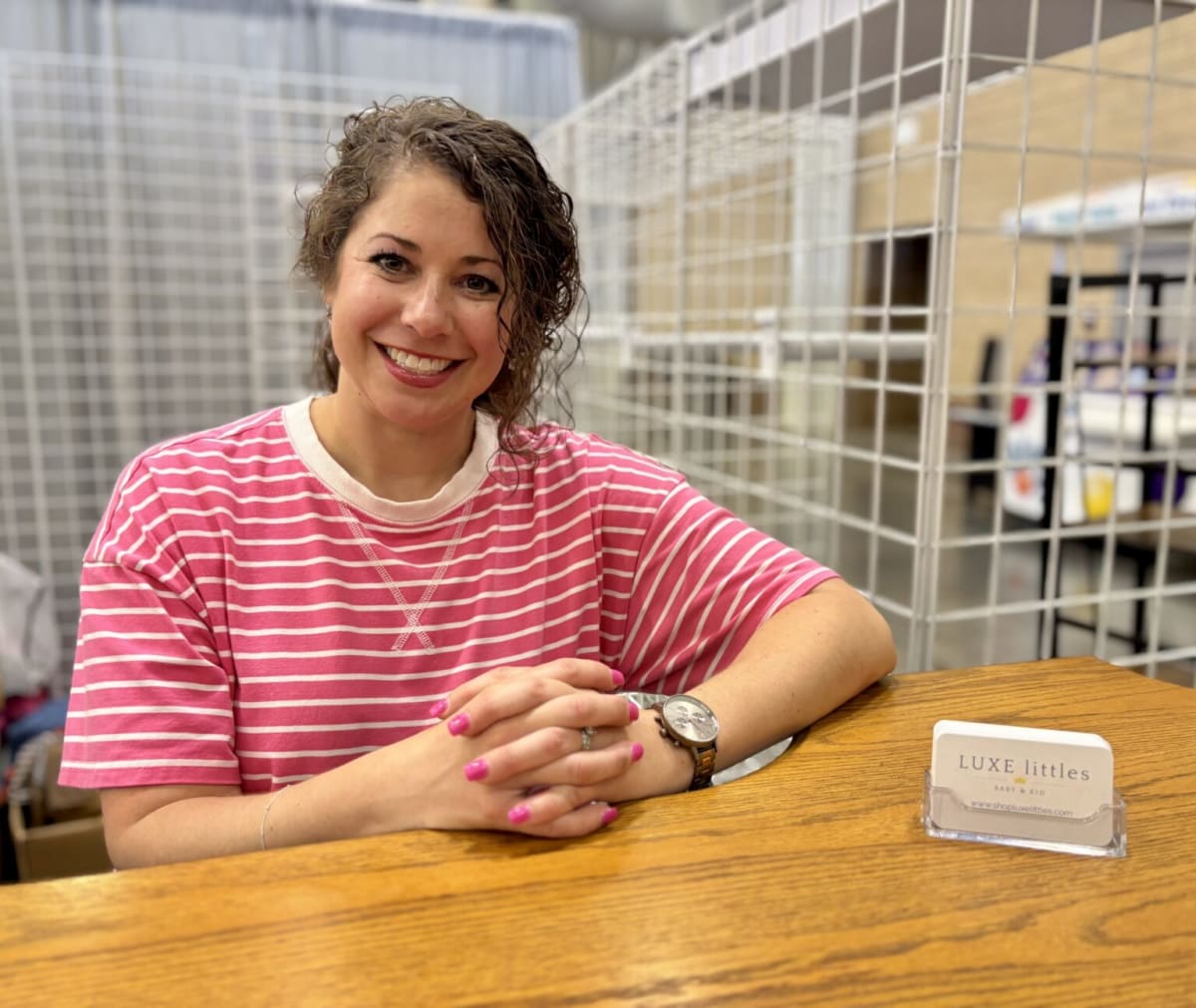 Teacher Kasey Bennett standing at her vendor booth smiling at Oklahoma County Fairgrounds
