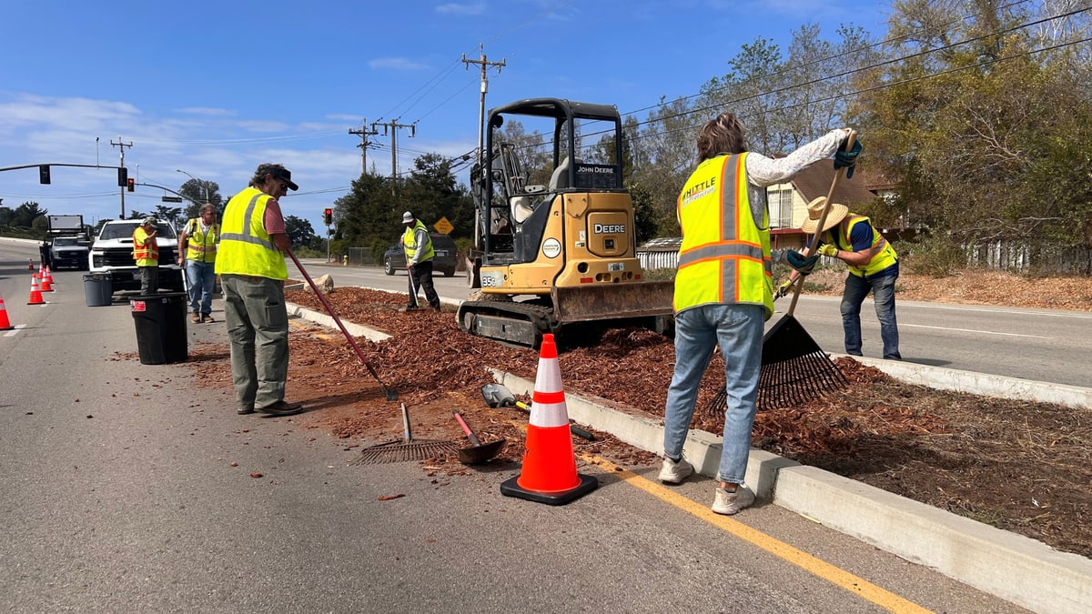 ** Rotary Club volunteers spreading mulch across highway median in Nipomo California