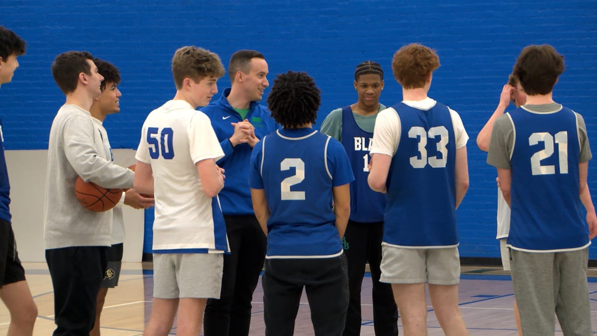 Blake School basketball players celebrating their unexpected section championship victory on court