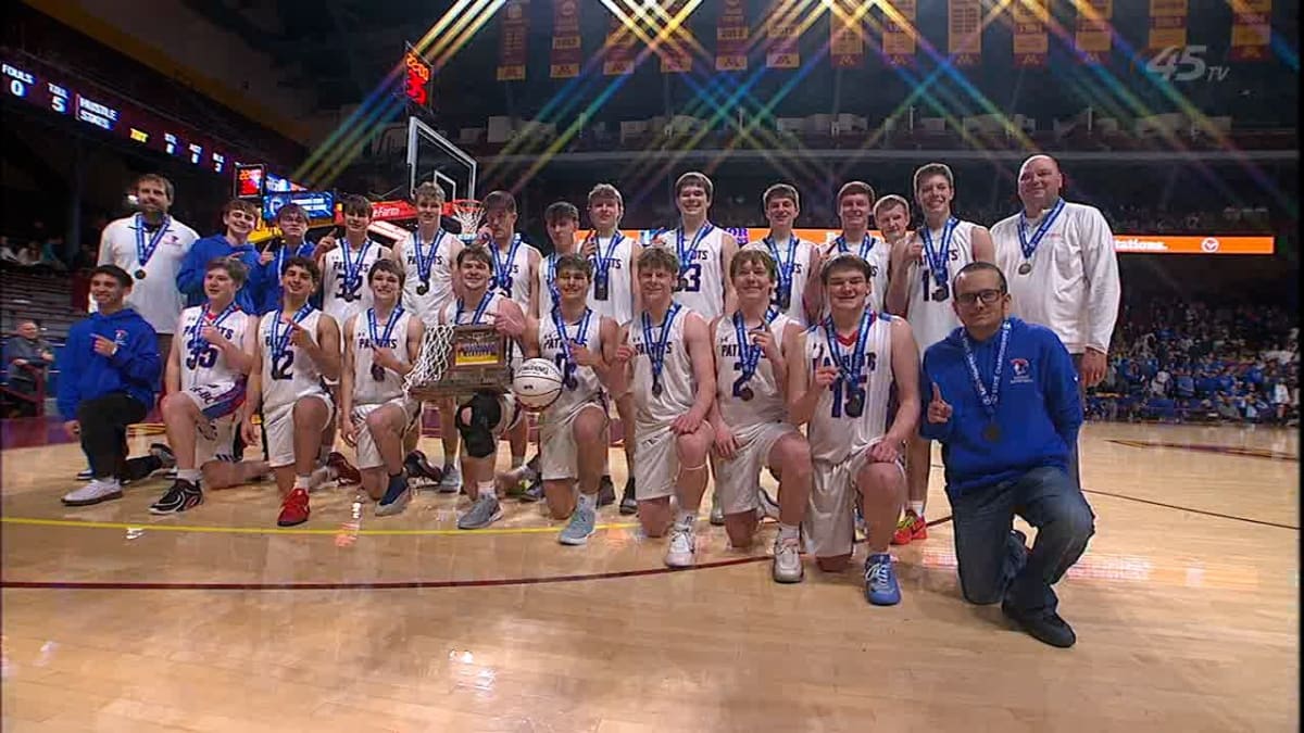 Hills-Beaver Creek Patriots basketball team celebrating with championship trophy at Williams Arena