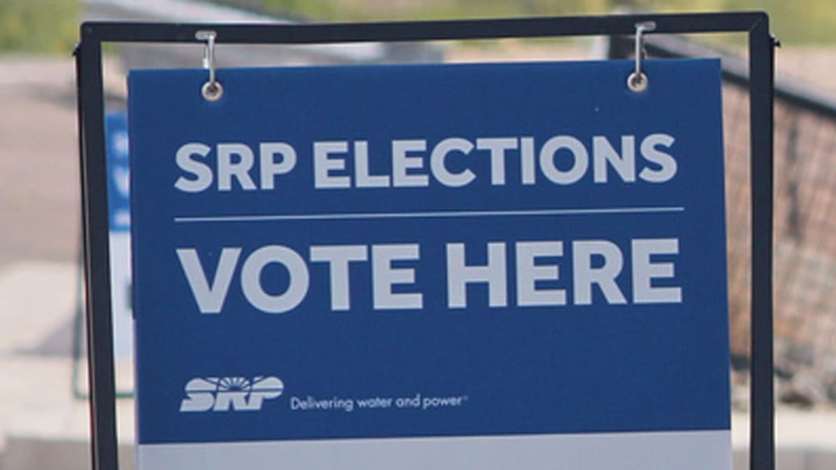 Solar panels gleaming in Arizona sunshine with Phoenix metro area skyline in background