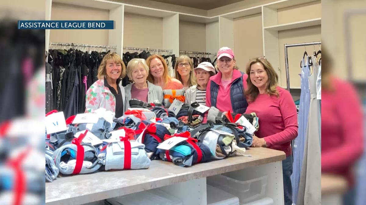 Volunteers organizing clothing racks at Assistance League Bend's Cinderella's Closet boutique program