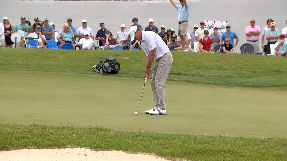 Steve Stricker putting on golf course with daughter Bobbi caddying beside him