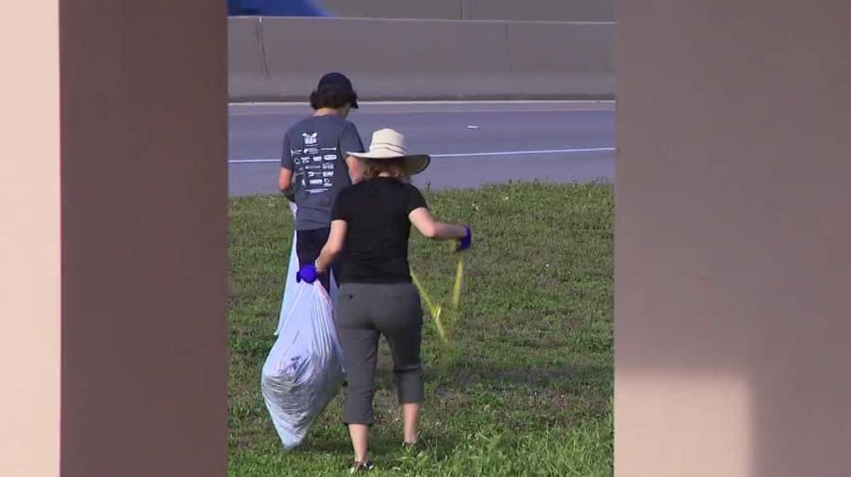 Volunteers collecting trash along waterway at Four Mile Cove Ecological Preserve in Cape Coral