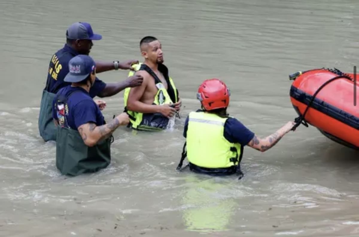 Dallas firefighters help Infant Guerrero remove lifejacket after flash flood rescue near Fair Oaks Park