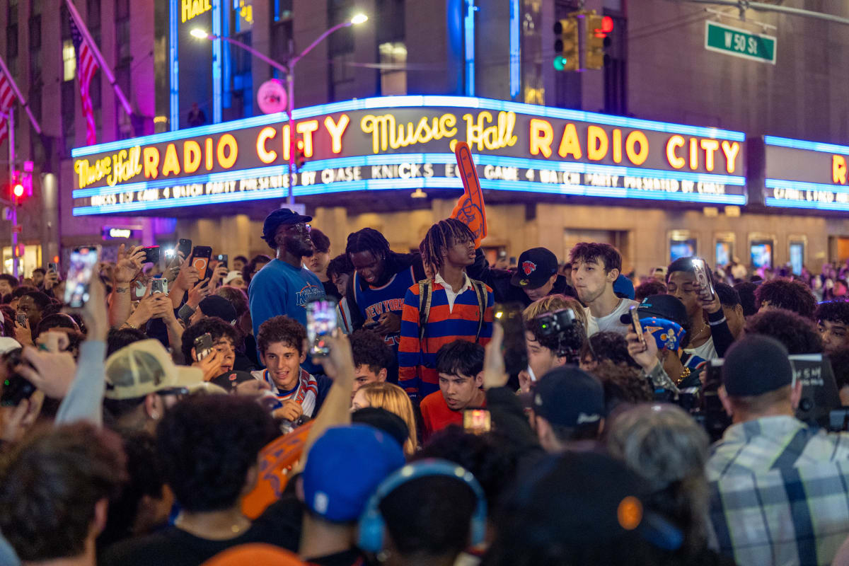 Diverse crowd of New York Knicks fans celebrating together at Radio City Music Hall