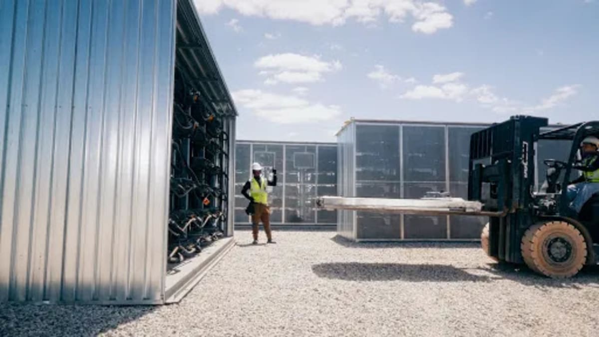 Retired electric vehicle batteries stacked in rows being repurposed for clean energy grid storage