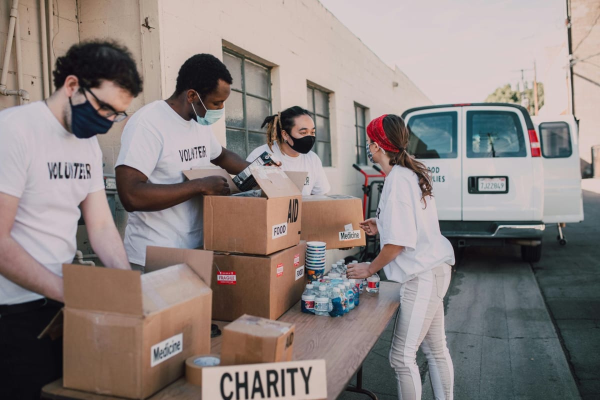 Diverse group of volunteers wearing matching crew shirts working together on community project