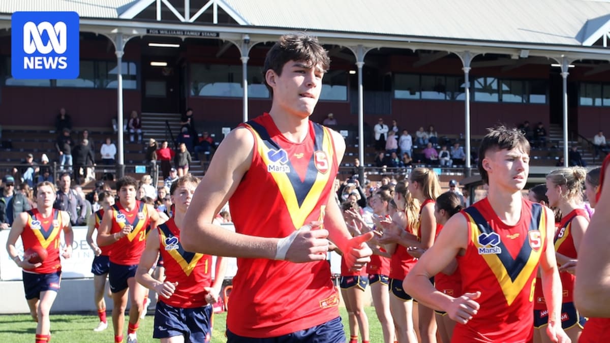Tall teenage athlete Jobe Janeway in Australian football uniform holding football