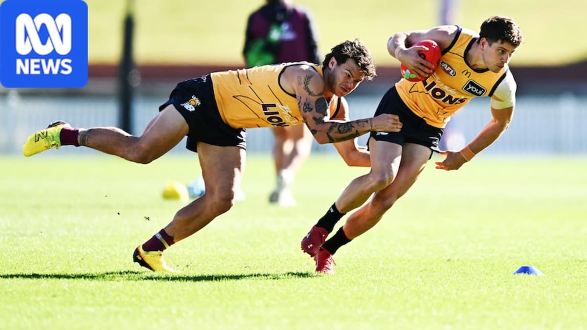 Australian Rules Football players during training session on green field showing physical contact