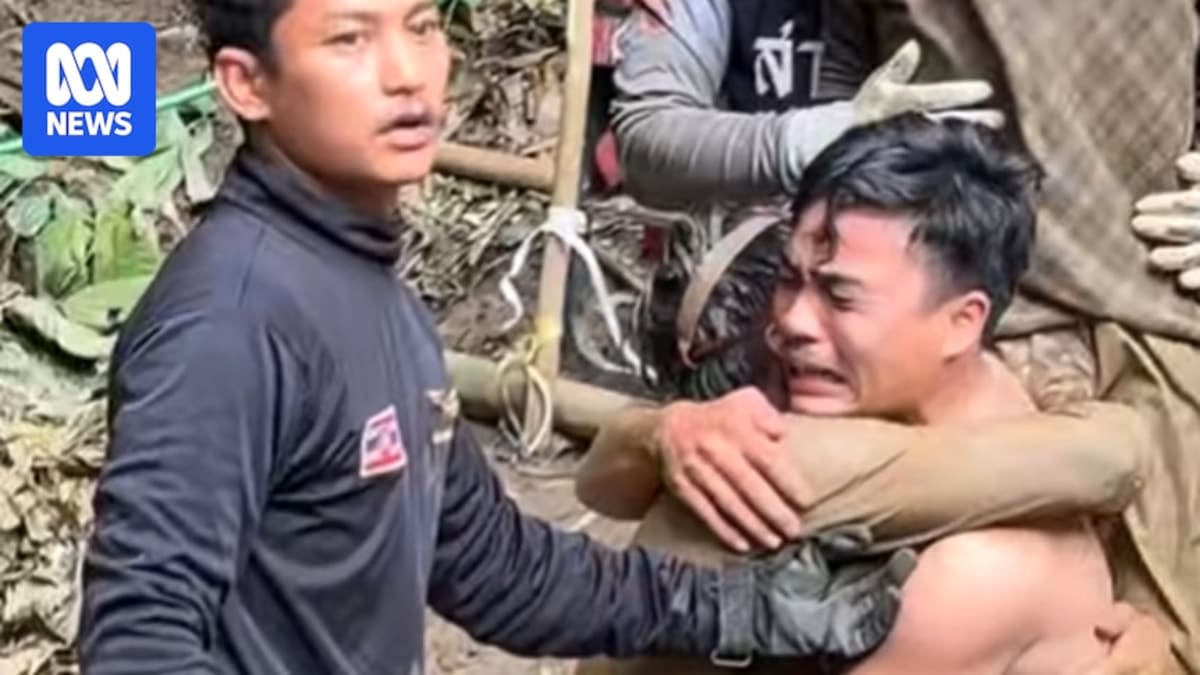 Villagers emerging from cave entrance as rescue workers and onlookers cheer their safe return