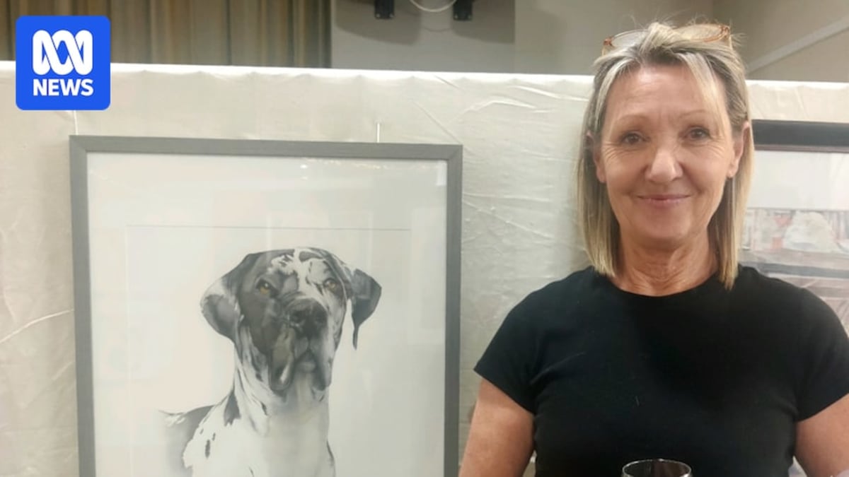 Artist displaying colorful original paintings in crowded arts pavilion at Sydney Royal Easter Show