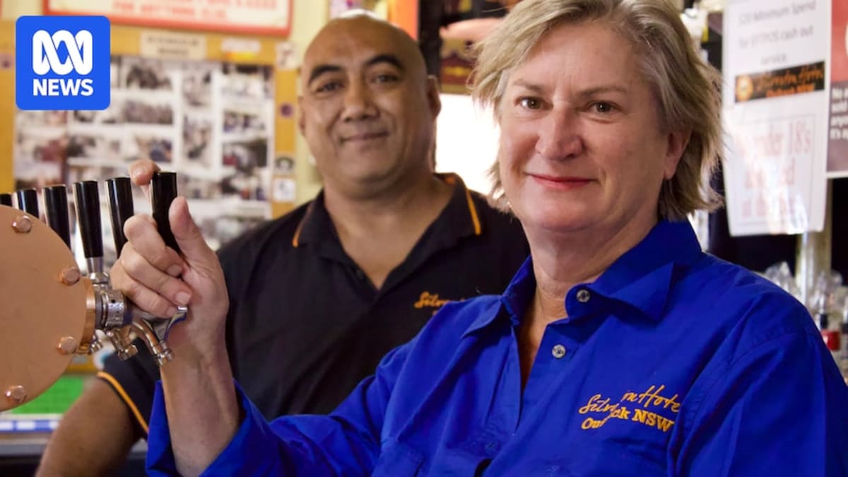 Smiling couple standing outside historic Silverton Hotel in outback New South Wales Australia