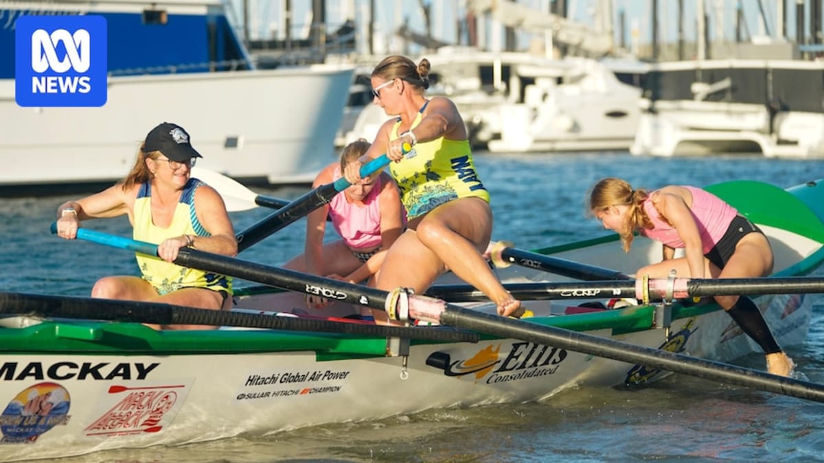 Four women rowing a white surfboat through ocean waves at sunrise in Mackay, Australia