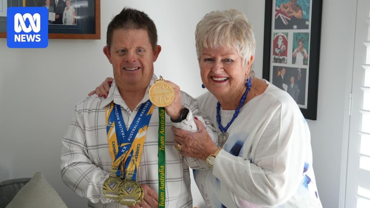 Clinton Super Fish Stanley smiling with his swimming medals and mother Sue Stanley