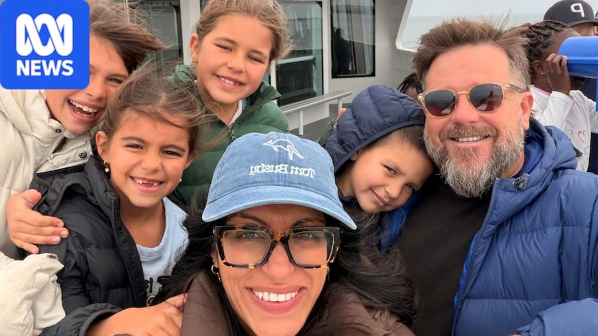 Tom and Huma Busby with their four young children standing together outdoors in Australia