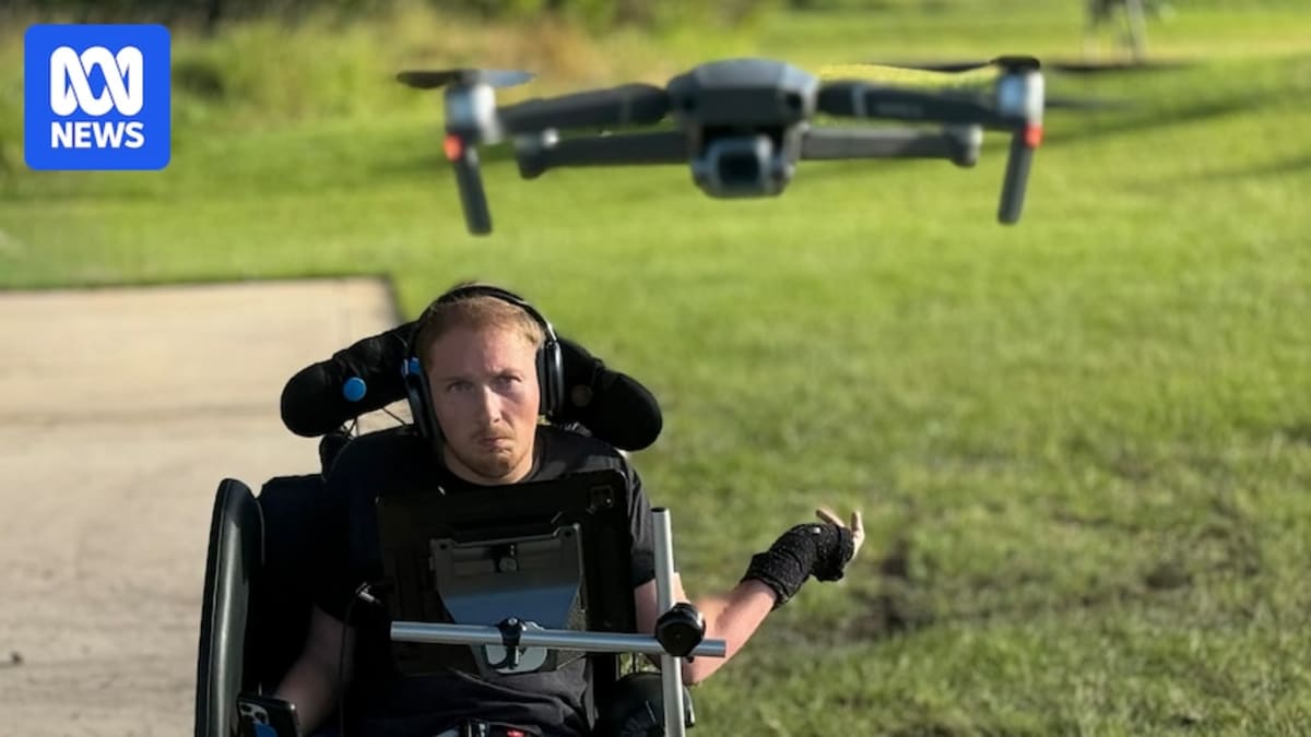 Christopher Hills in his wheelchair using head-mounted controls to pilot a drone outdoors