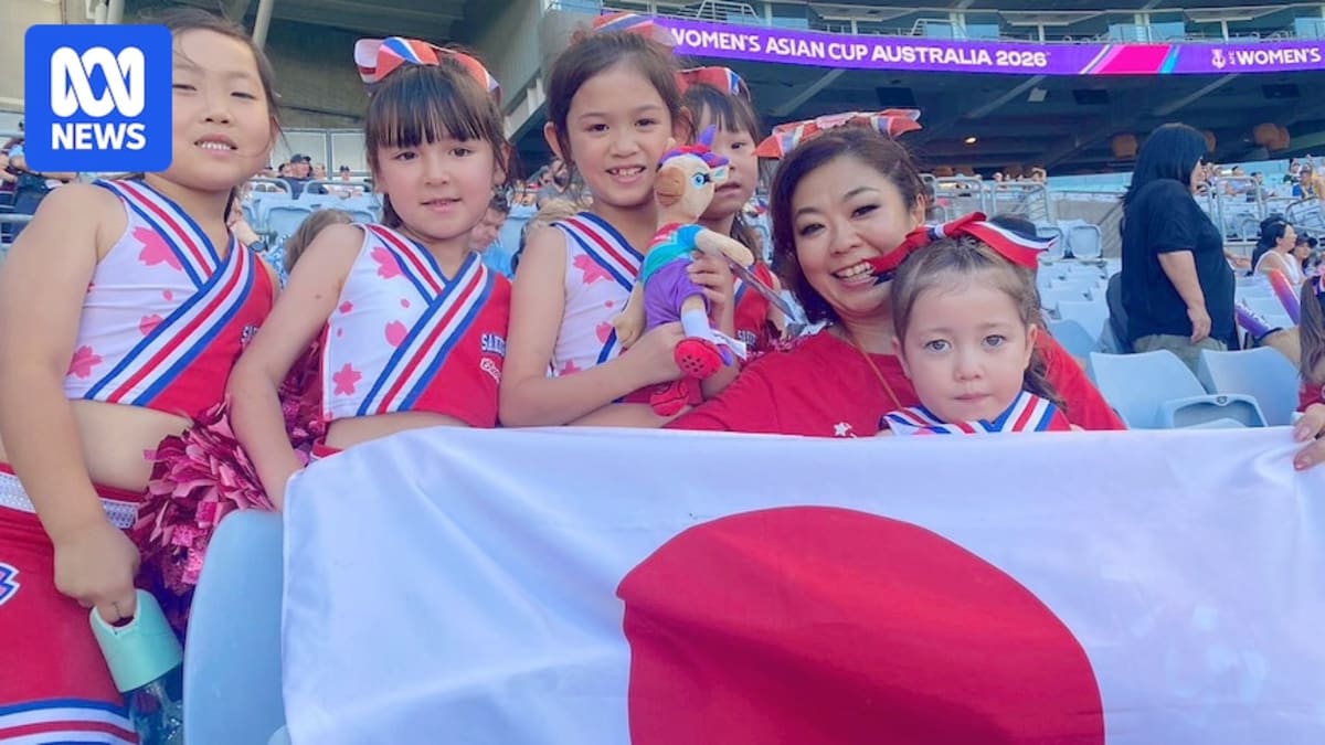 Young cheerleaders in matching uniforms performing traditional Japanese chants at soccer fan zone