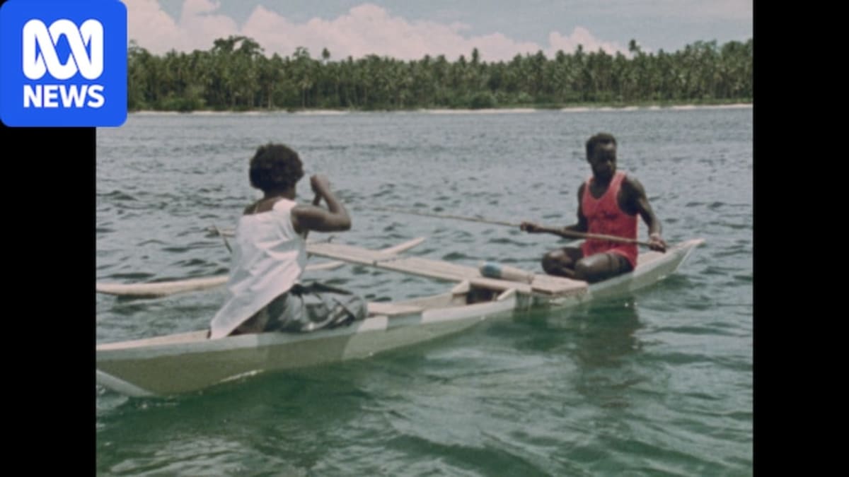Film archivist carefully handling old film reels in Papua New Guinea preservation project