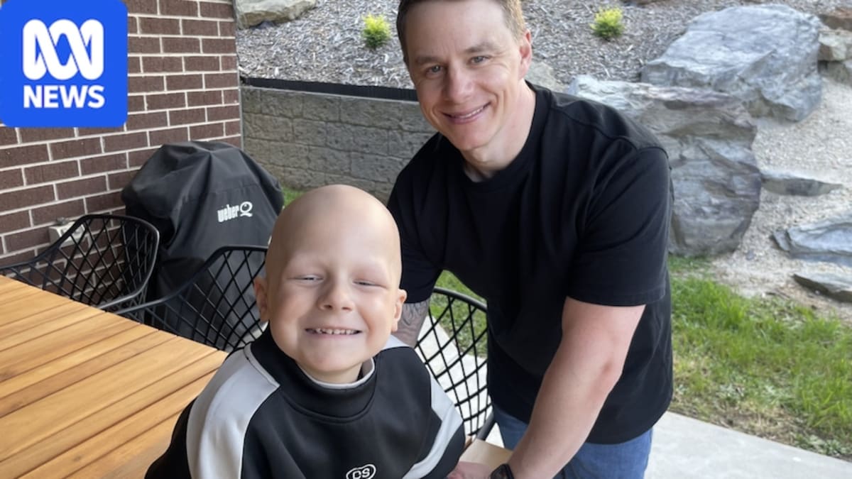 Six-year-old Logan Goldfinch and his dad Shane celebrating at home during AFL ceremony