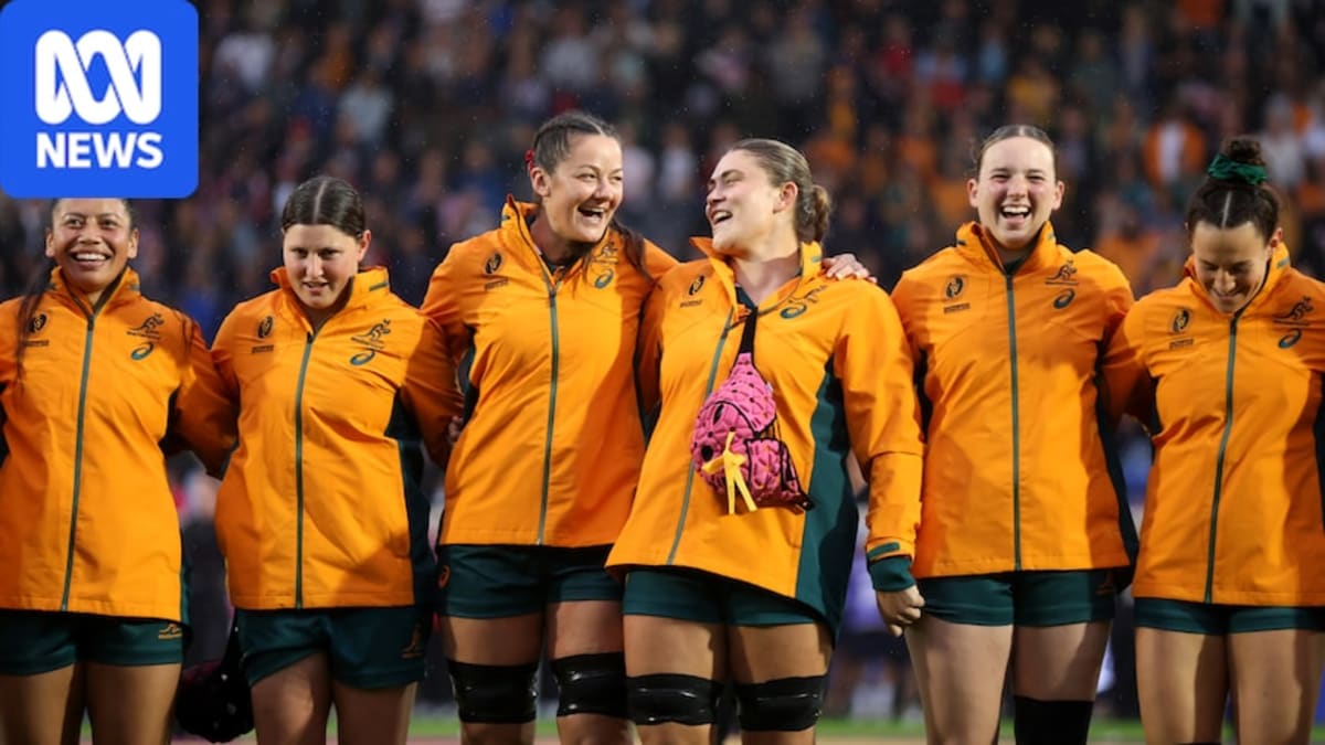 ** Wallaroos rugby players in green and gold jerseys celebrating together on field