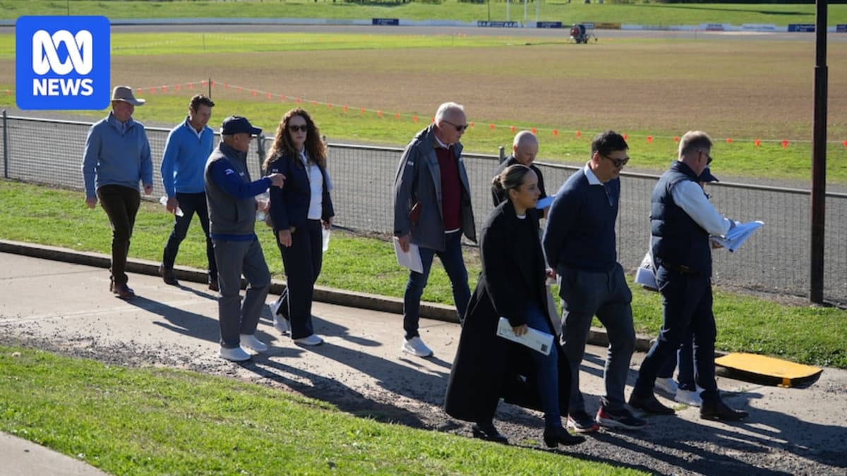 International officials touring Toowoomba Showgrounds with maps reviewing Olympic equestrian venue plans