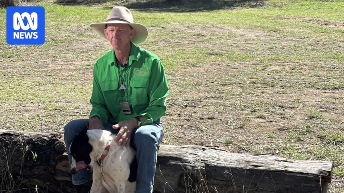 Zookeeper Scott Smith kneeling beside his border collie Ace at the National Sheep Dog Trials competition