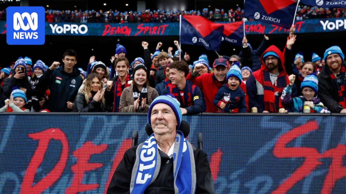 Neale Daniher smiling at Big Freeze fundraiser event wearing winter beanie surrounded by supporters