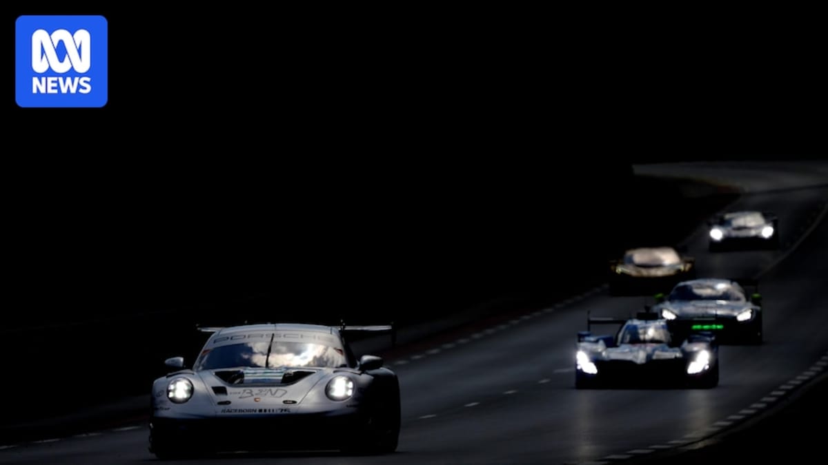 Yasser Shahin and teammates standing beside their number 92 Porsche race car at Le Mans