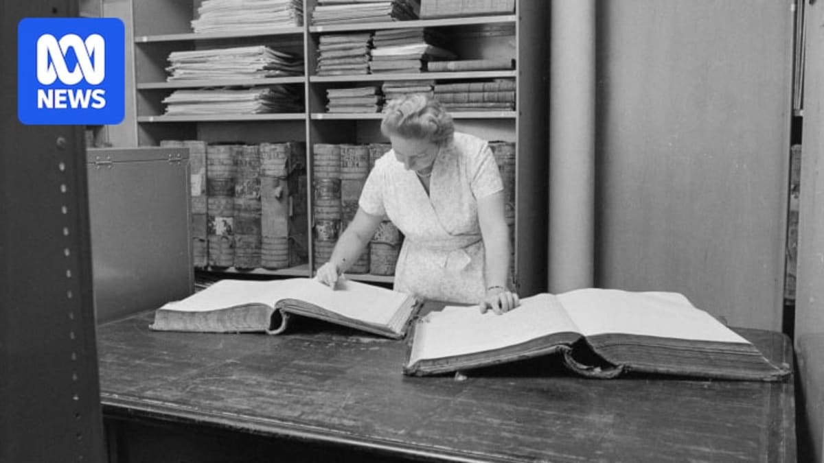Margaret Medcalf at 100 years old examining historical maps with senior archivist at State Records Office