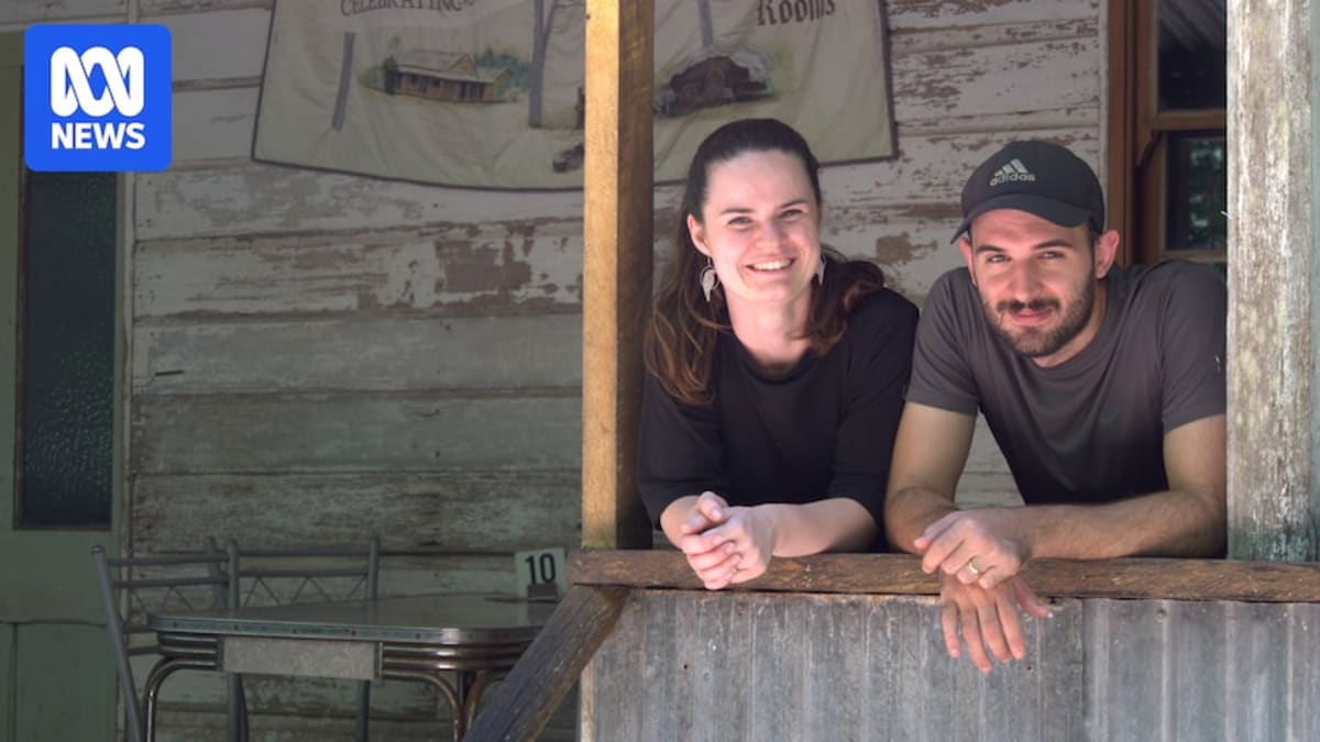 Young couple standing outside historic wooden-slab hotel building in rural Queensland Australia