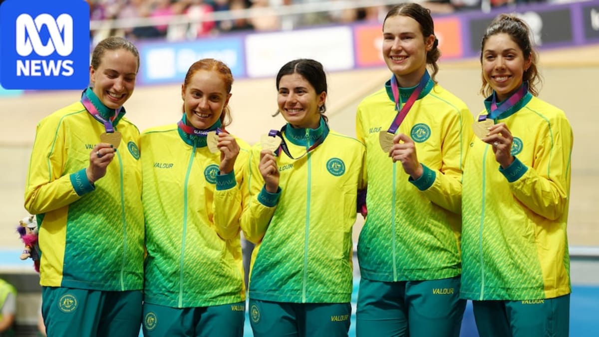 Tara Neyland celebrating with arms raised after winning gold medal at velodrome cycling event