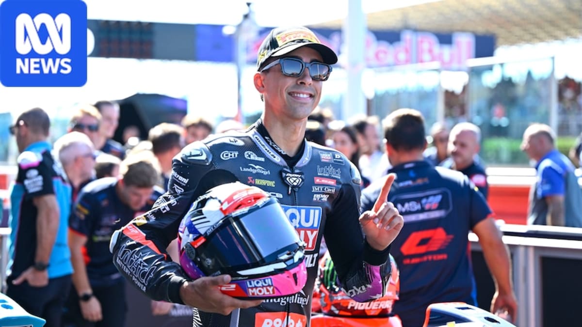 Young motorcycle racer Senna Agius in racing gear celebrating on track