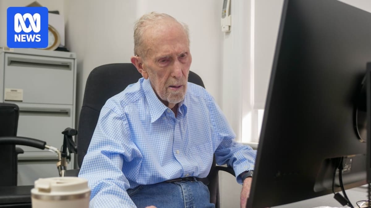 Dean Simes, 102, smiling while teaching computer skills to seniors at Computer Pals club