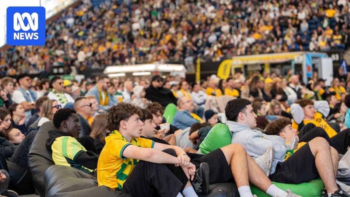 Fans in green and gold jerseys celebrating at The Drive venue in Adelaide, Australia