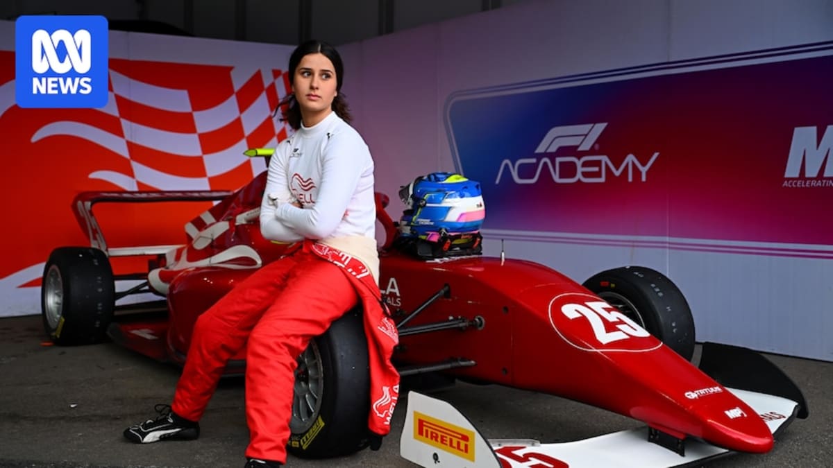 Teenage racing driver Joanne Ciconte in racing suit standing beside Formula race car