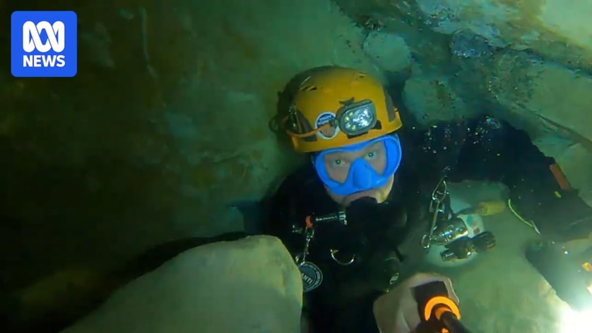 Josh Richards in diving gear exploring an underwater cave passage in South Australia