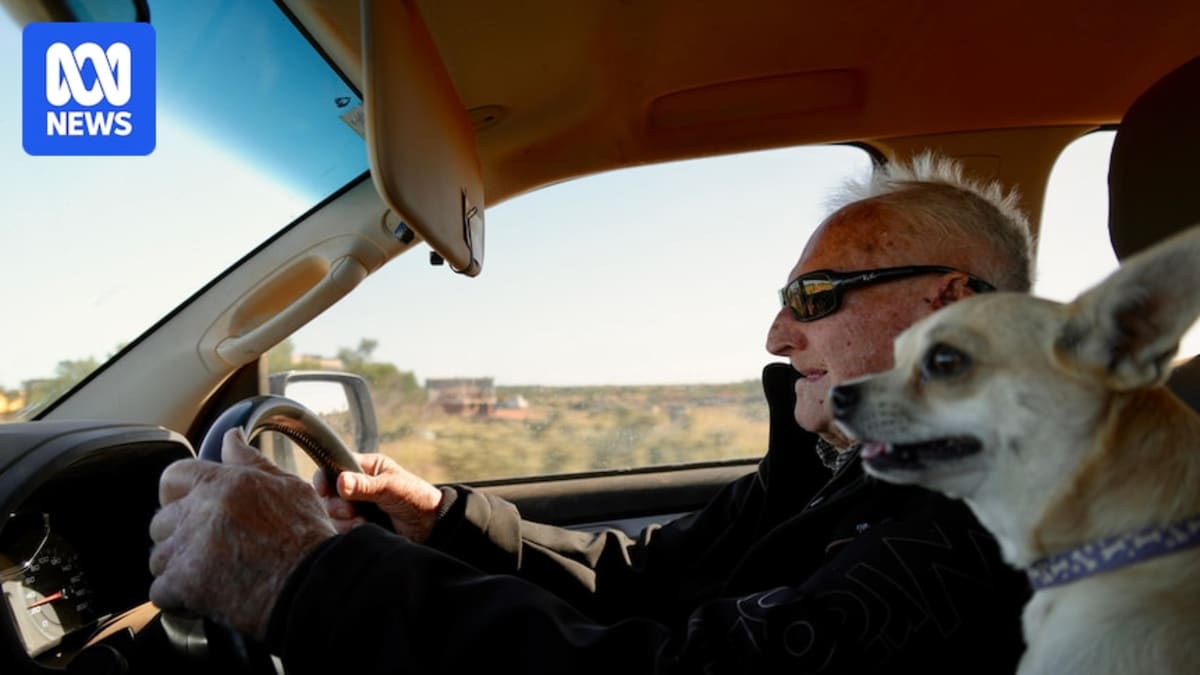 ** Elderly man on mobility scooter with small chihuahua dog at Australian cattle ranch