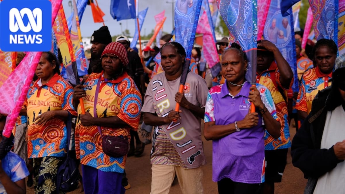 Large crowd marching through Australian Outback landscape during Gurindji Freedom Day Festival anniversary celebration