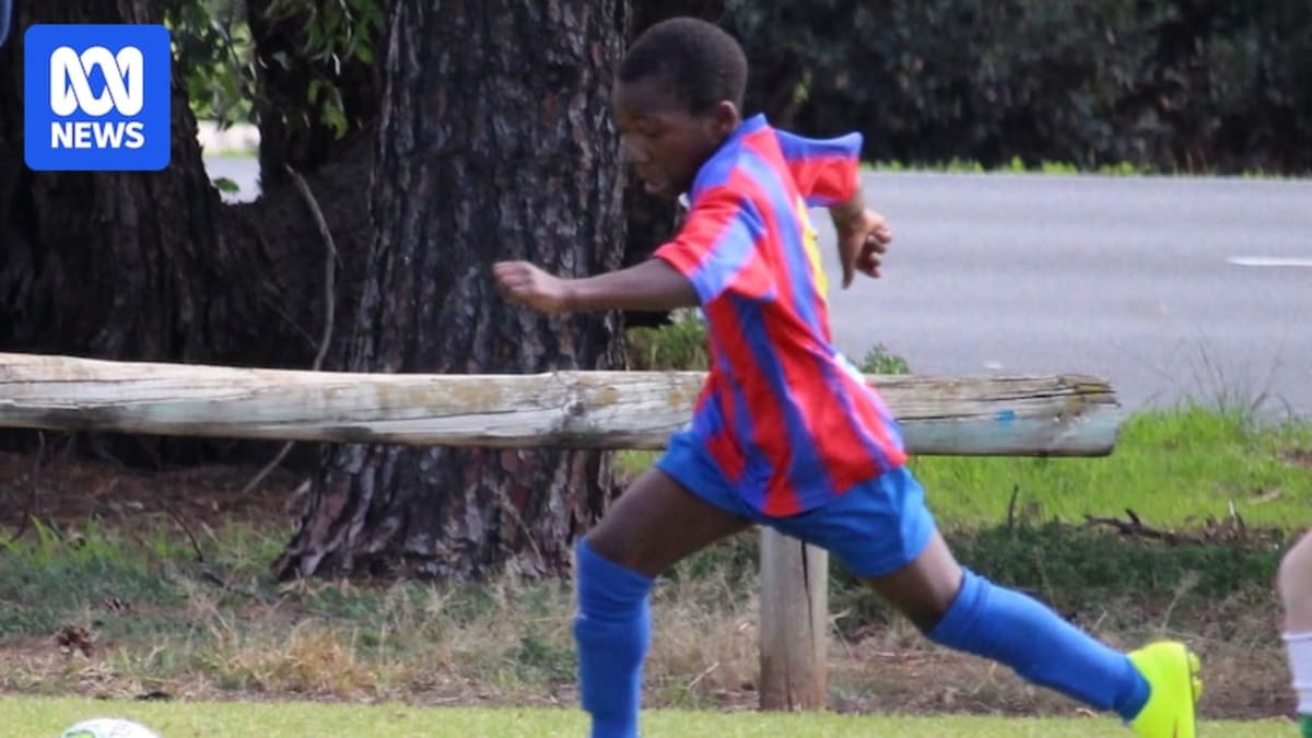 ** Young Nestory Irankunda in blue Northern Wolves Soccer Club uniform kicking soccer ball on grass field