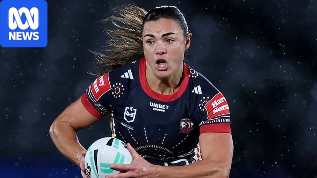 Millie Elliott in Sydney Roosters jersey celebrating championship win on rugby field