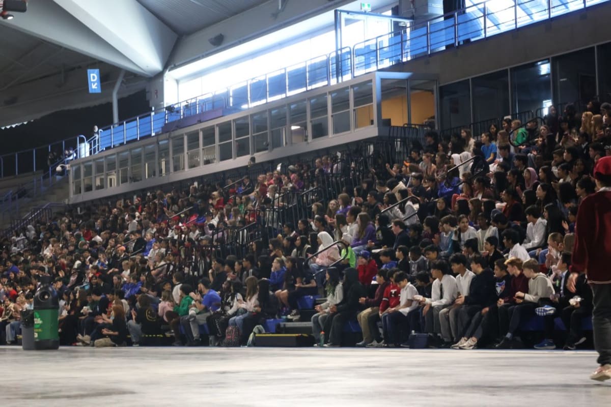 Students presenting science fair projects at tables inside Calgary's Olympic Oval venue