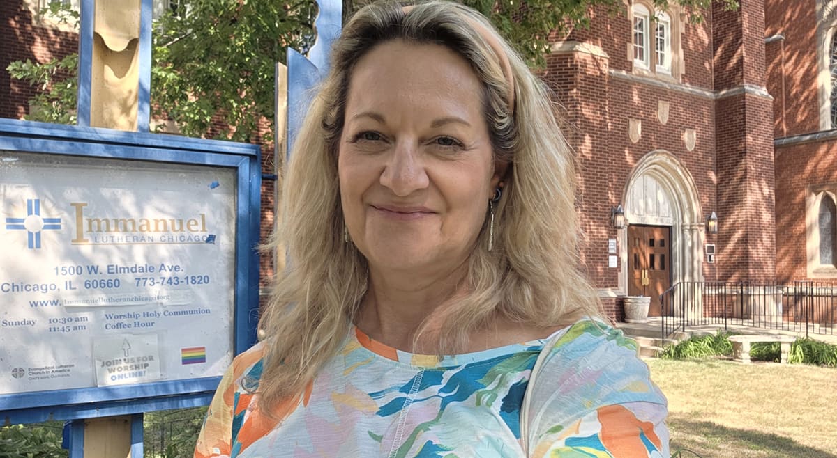 Woman standing outside diverse religious buildings in Chicago holding verification forms and smiling