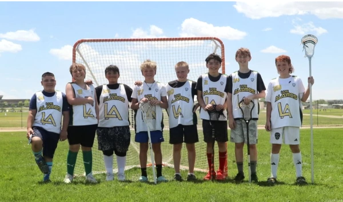 Youth lacrosse team from Los Alamos posing together with championship trophy at tournament