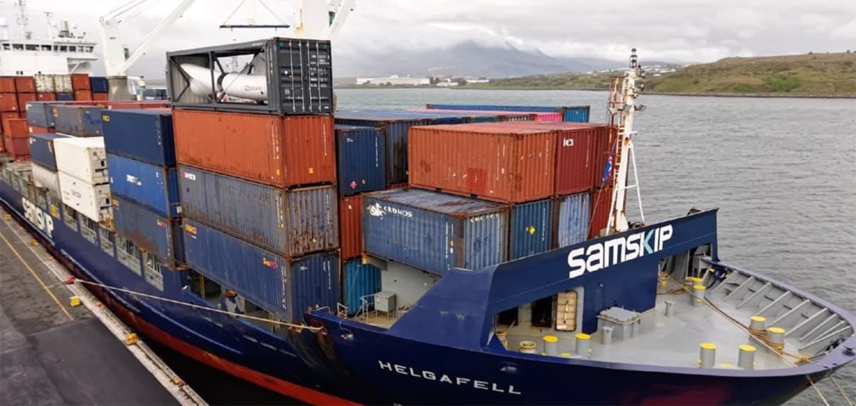 Modified shipping container with horizontal wind turbine and solar panels installed on cargo ship deck