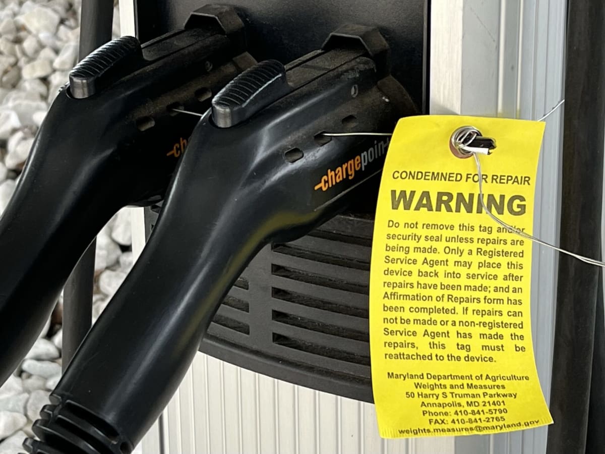 ** Yellow inspection tag and wire seal on electric vehicle charging port in Maryland