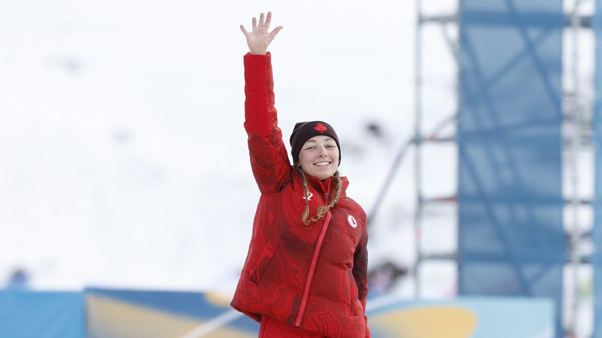 Paralympic skier Natalie Wilkie celebrating on podium wearing Canada team uniform and medal