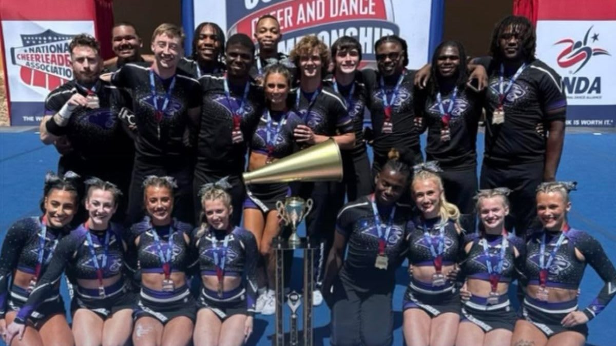 McKendree University cheerleading team celebrating their NCAA national championship victory with coach Zach Mittman