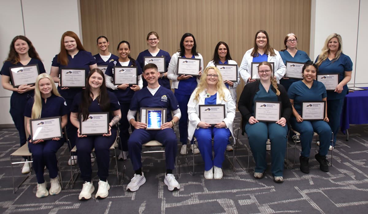 Two smiling students holding awards at healthcare education ceremony in Kentucky community college