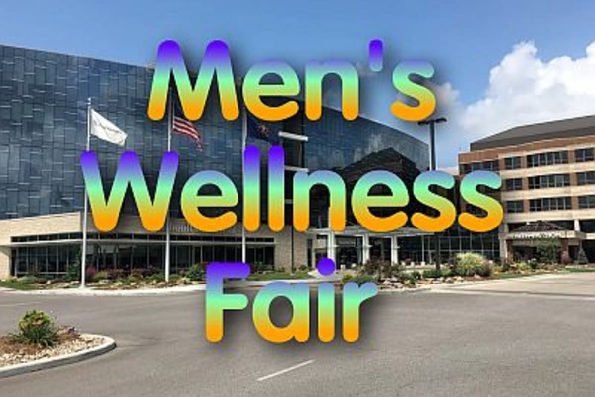 Healthcare worker taking blood pressure reading from male patient at community health fair